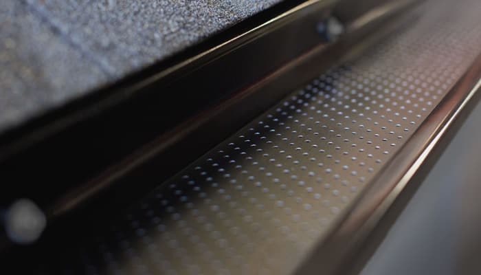 Finished gutter and downspout integration at roof edge